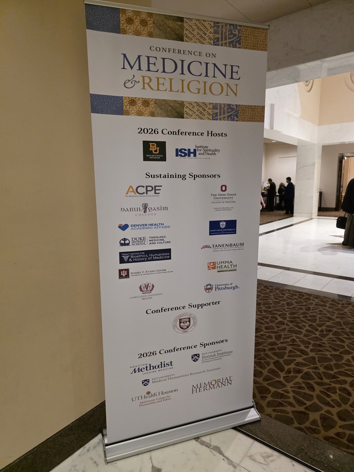 Roll-up banner for 2026 Conference on Medicine and Religion displaying conference hosts, sustaining sponsors, and supporter logos